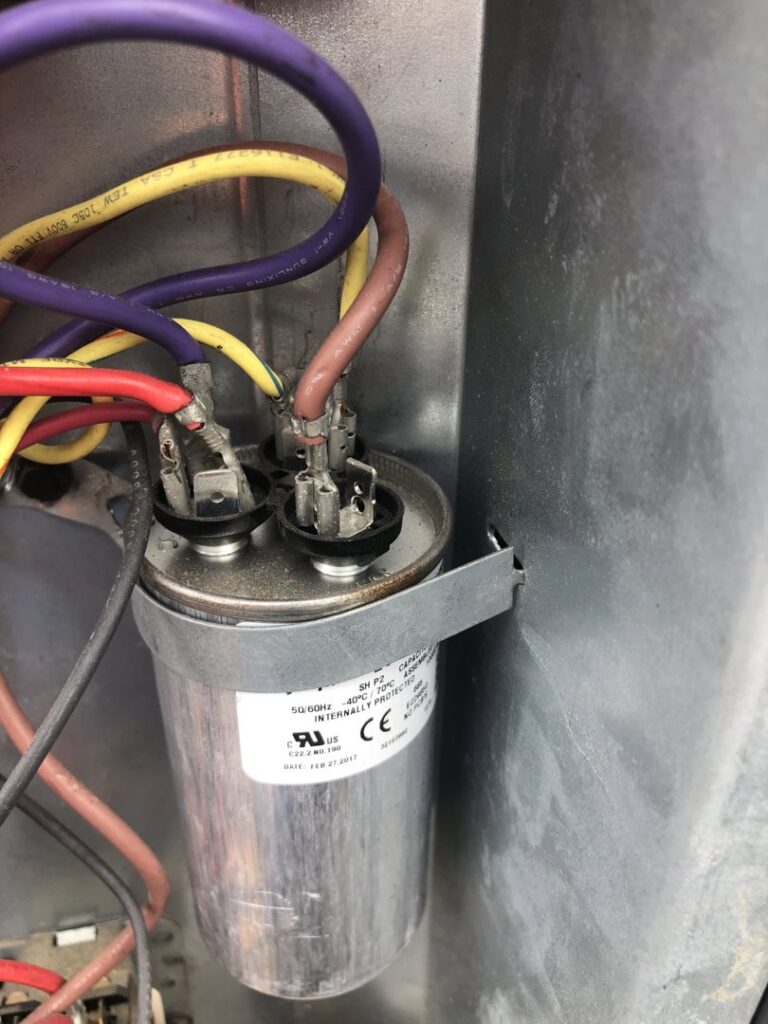 A close-up view of an HVAC capacitor and wiring, indicating repair or inspection by 4-BIS Solutions HVAC and Home Maintenance in Columbia, MO.