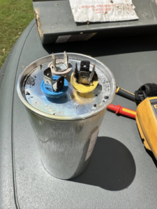 A close-up of an HVAC capacitor, indicating a repair or replacement service by Dynamic Comfort Solutions in York, PA.