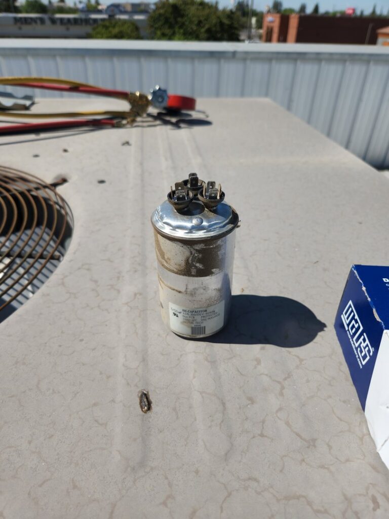 An HVAC capacitor on a rooftop unit, indicating repair or maintenance by All Pro Air in Warrenville, IL.