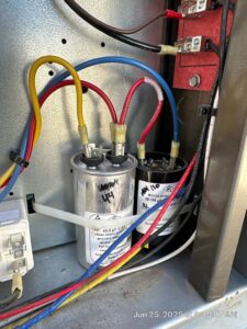 Close-up of HVAC capacitors and wiring inside an electrical panel, indicating a replacement or repair by Kade Mechanical in Phoenix, AZ.