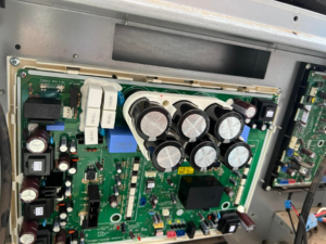 A detailed view of an HVAC circuit board with capacitors, indicating repair work by Evans Heat & Air in Ruther Glen, VA.
