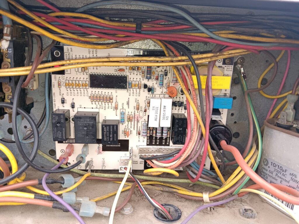 Close-up of an HVAC unit's circuit board with wiring, indicating repair or maintenance by JJJ Techs Heating and Cooling in Kinzers, PA.