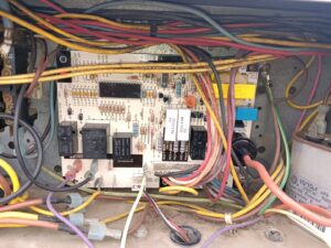 Close-up of an HVAC unit's circuit board with wiring, indicating repair or maintenance by JJJ Techs Heating and Cooling in Kinzers, PA.