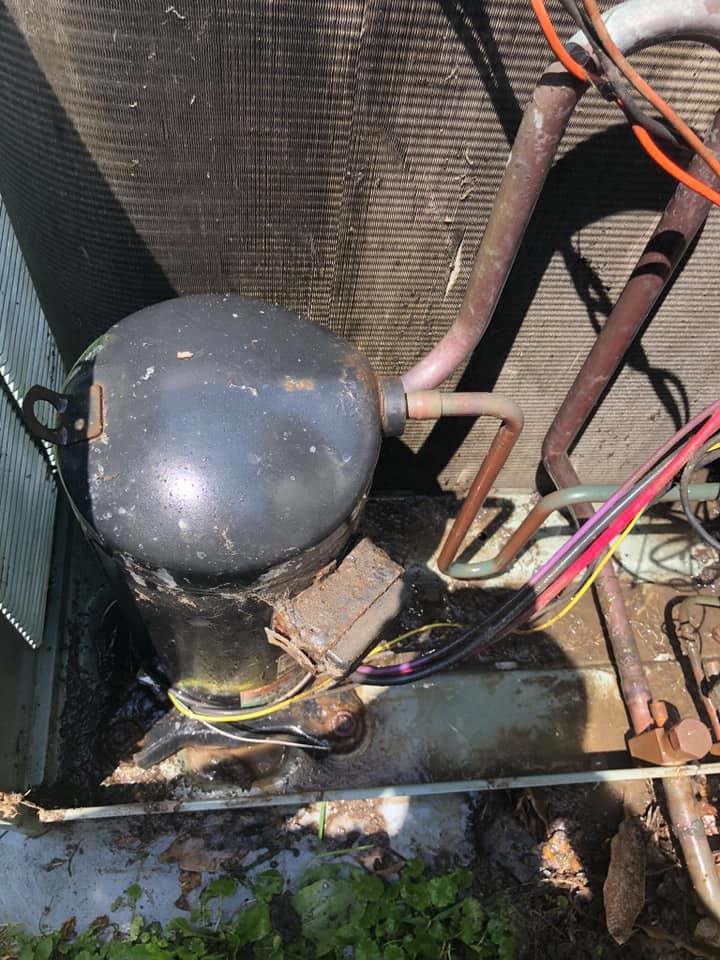 An HVAC compressor and copper lines inside an outdoor unit undergoing inspection or repair by L.N.P Heating & Cooling in Columbus, OH