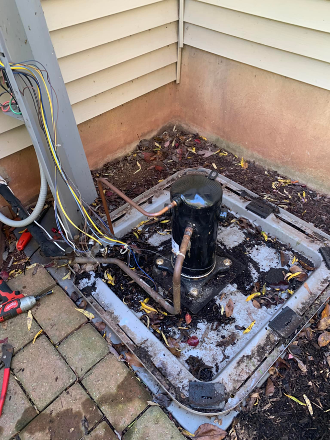 An HVAC compressor unit base with copper lines and tools, indicating service work by aghapy 1 in Jersey City, NJ