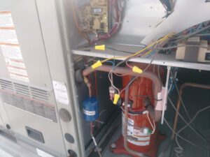 Close-up of an HVAC compressor and wiring inside an outdoor unit, showing repair by Bean'z Heating and Cooling in Chicago, IL.