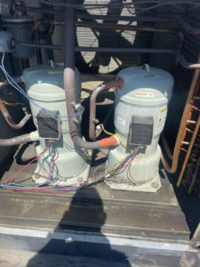 Close-up view of HVAC compressors and wiring inside an outdoor unit by Mason Mechanical Services LLC HVAC Frederick Md in Jefferson, MD.