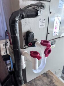 Newly installed HVAC condensate drain lines with a P-trap and cleanouts by Mueller Mechanical HVAC in Philadelphia, PA.