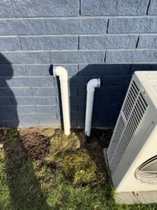 Condensate drain pipes installed next to an outdoor HVAC unit by LeoAir, LLC in West Jordan, UT.