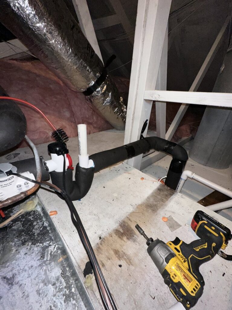 An HVAC condensate trap and insulated lines with a power drill nearby, indicating an installation or repair by Love HVAC LLC in Bluffton, SC.