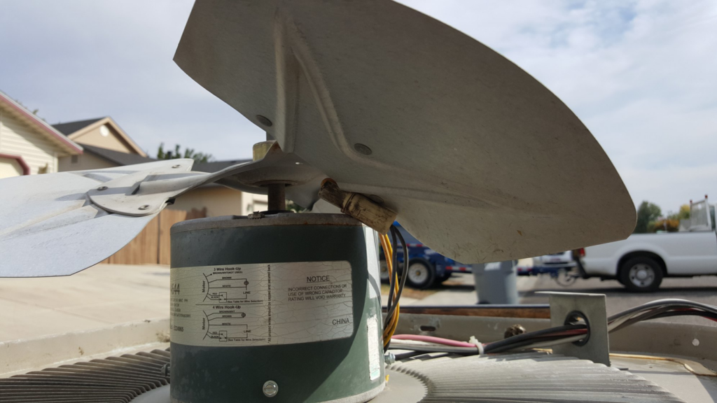 A close-up of an HVAC condenser fan motor and blades, showing a repair by Air Conditioning and Heating Service of Meridian, ID
