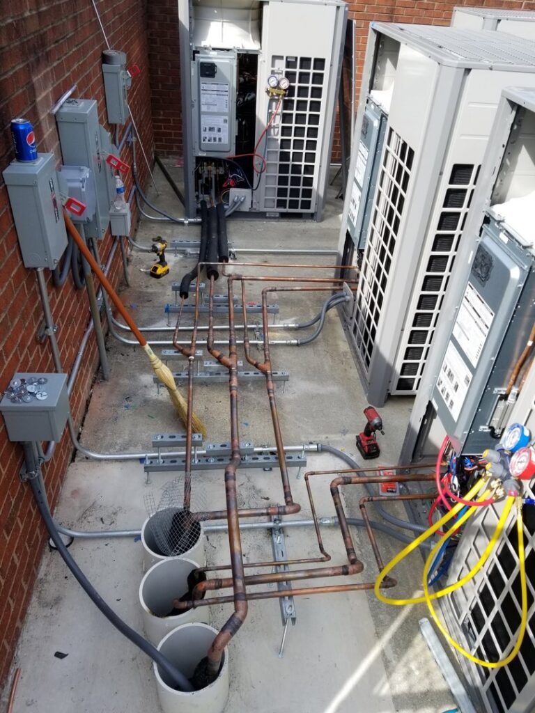 Outdoor HVAC condenser units with copper piping and electrical work being installed by Comfort Systems of Virginia, Inc. in Chesapeake, VA.