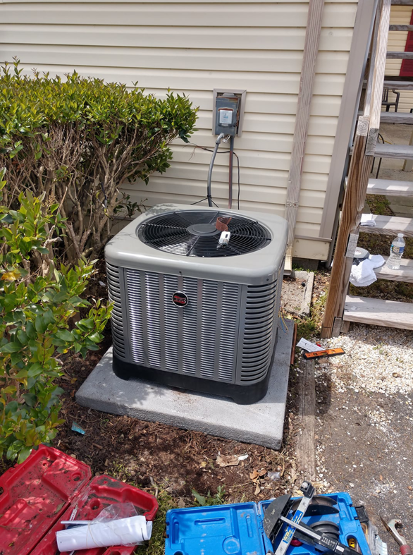 An outdoor HVAC condenser unit installation with tools on the ground by Ryans Ambient Air in Portsmouth, VA.