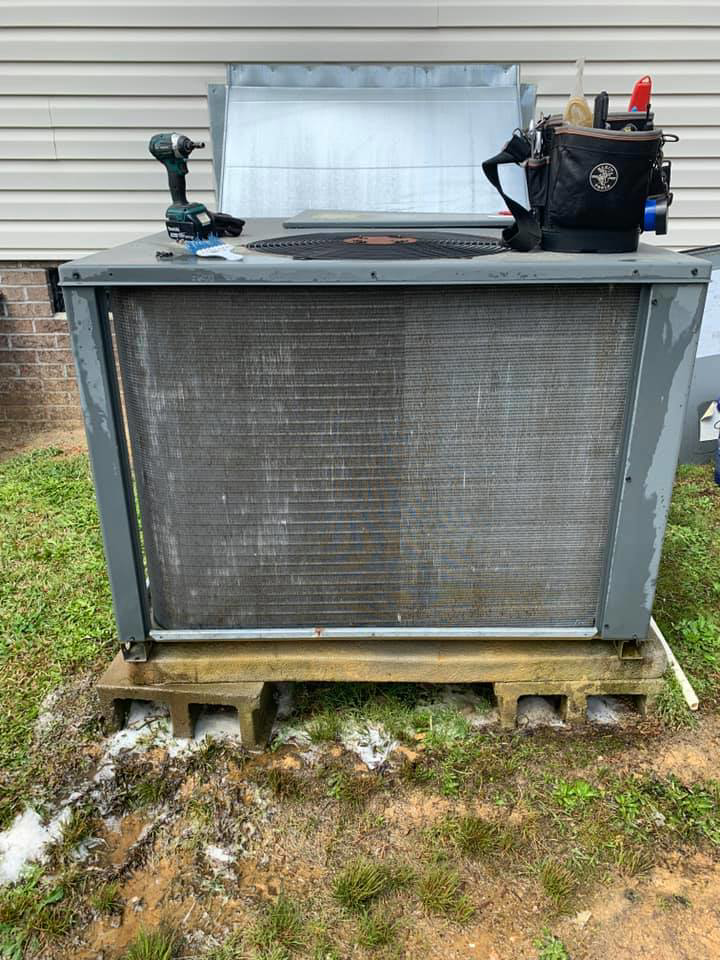 An outdoor HVAC condenser unit with its top open, showing coils during maintenance by Ammons Mechanical LLC in Durham, NC.