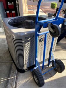 An HVAC condenser unit being moved on a dolly by Rebel Refrigeration in Las Vegas, NV.