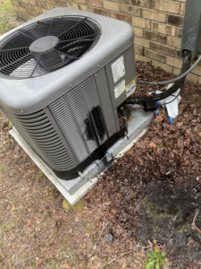 An outdoor HVAC condenser unit showing a leak or stain, indicating a repair job by Kirk Heating & Air Conditioning in Summerville, SC.