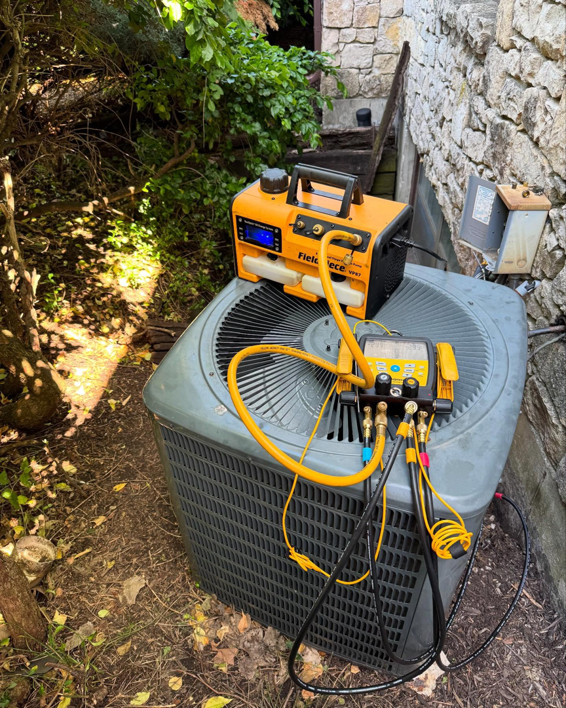 An outdoor HVAC condenser unit undergoing service with specialized tools by Rose Legacy Hvac in Overland Park, KS.