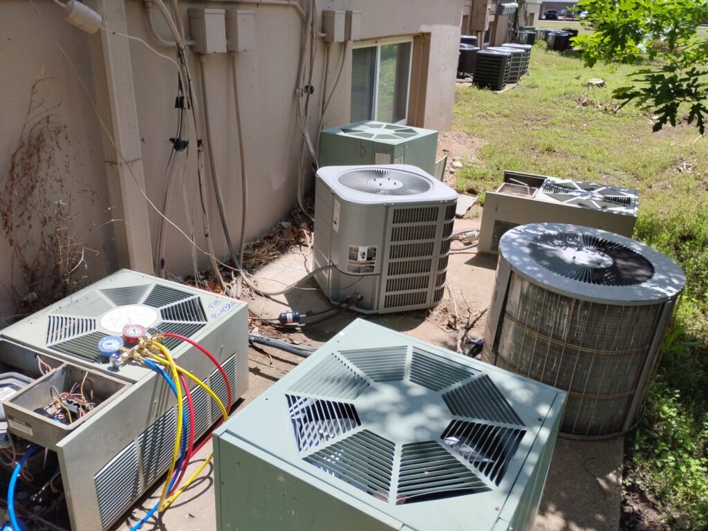 Multiple outdoor HVAC condenser units being serviced and installed by Cool Guys Heating & Air in Georgetown, TX.