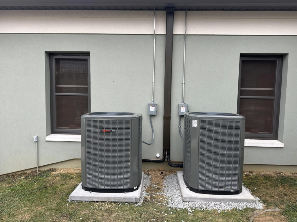 Detailed view of two outdoor HVAC condenser units with electrical conduit installed by R&R Climate Systems in Newark, NJ