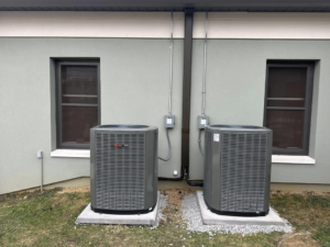 Detailed view of two outdoor HVAC condenser units with electrical conduit installed by R&R Climate Systems in Newark, NJ