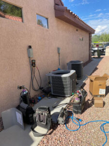 Two outdoor HVAC condenser units with tools and equipment laid out for service or installation by Blue Collar Mechanical LLC in Indianapolis, IN.