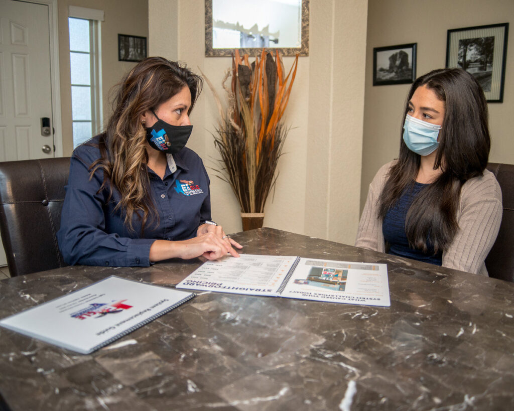 An Eagle Heating & A/C representative discussing HVAC options with a customer in San Antonio, TX.