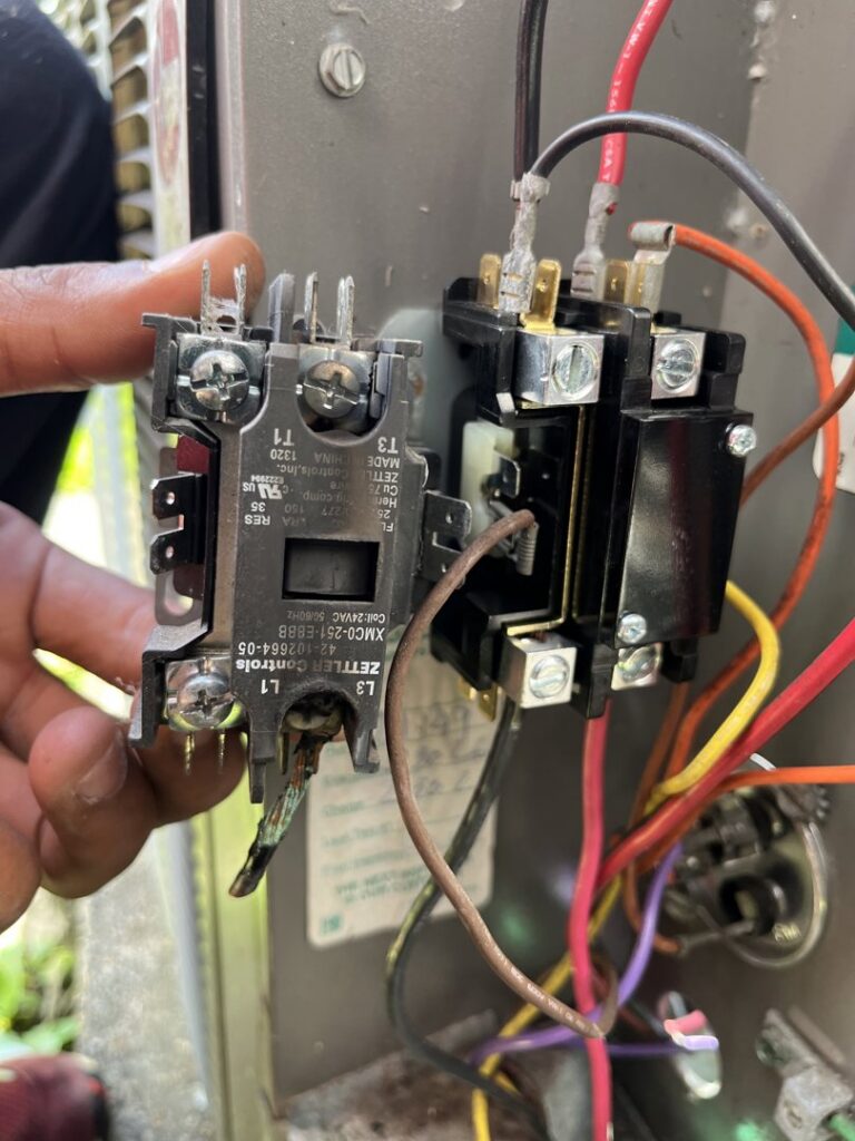 A technician holding an electrical contactor during an HVAC repair or replacement service by Keith HVAC & Electrical Enterprises LLC in New Orleans, LA.