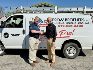 Two HVAC contractors shaking hands in front of a Prow Brothers service van for Leap Partners in Greensboro, NC.