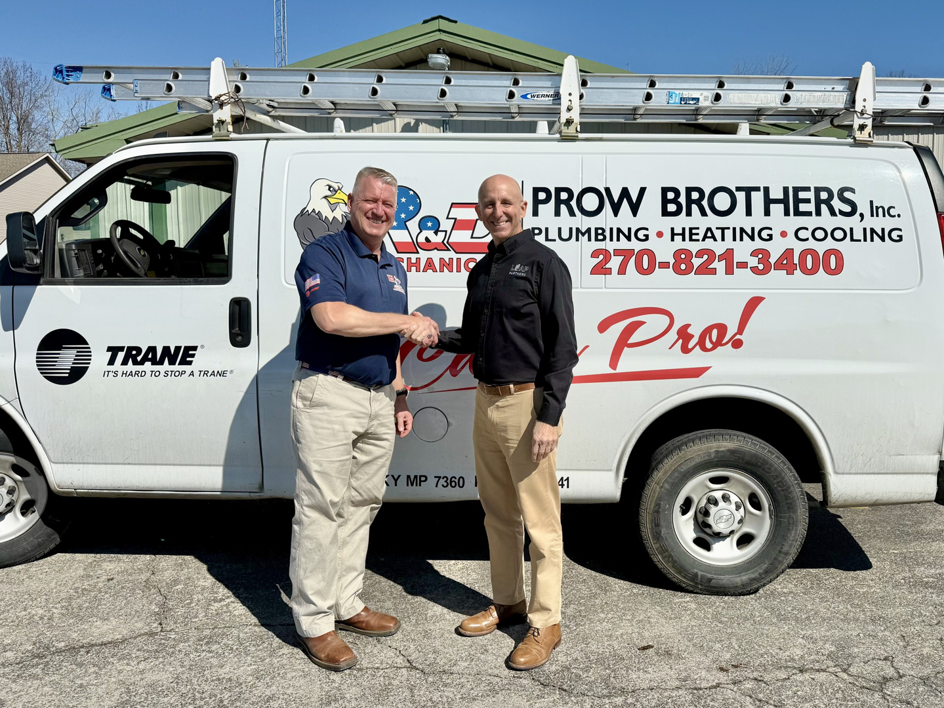 Two HVAC contractors shaking hands in front of a Prow Brothers service van for Leap Partners in Greensboro, NC.