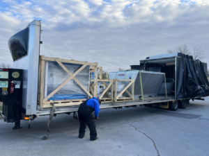 An HVAC contractor from HBC unloading new heating and cooling units from a delivery truck in Cranston, RI.