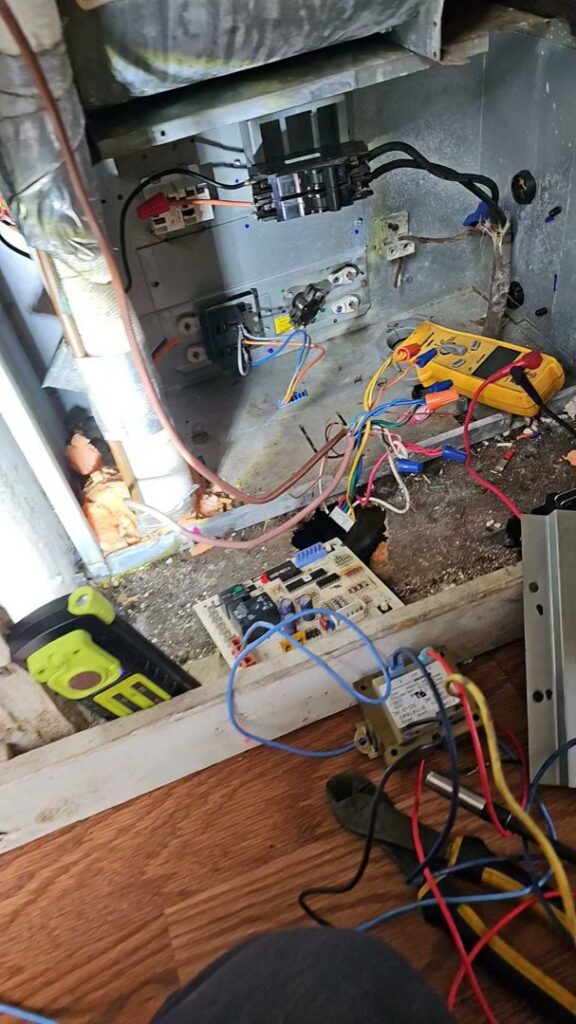 An HVAC control board with a multimeter connected for diagnosis or repair by Anubis Mechanical in Goose Creek, SC.