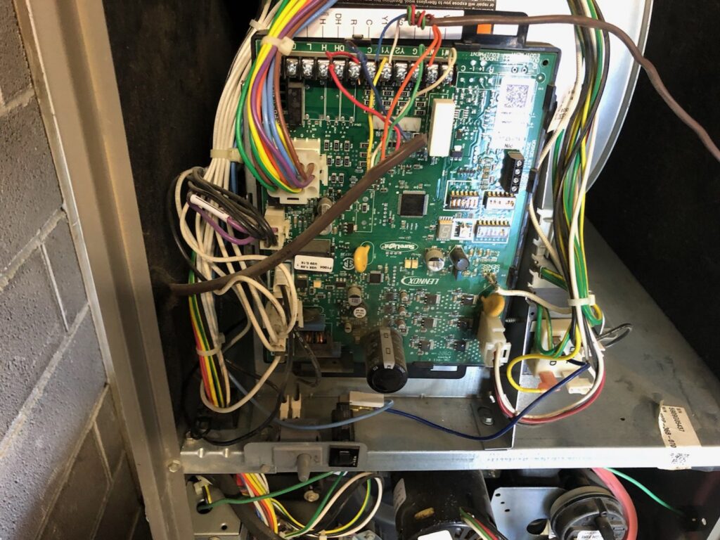 A close-up view of an HVAC control board with wiring, indicating repair or maintenance by Awesome Air Heating and Cooling LLC in Corvallis, OR.
