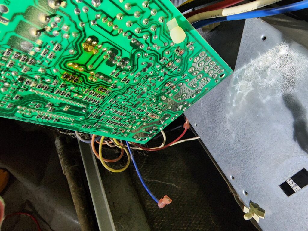 A close-up view of an HVAC control board with various wires, likely during diagnostics or repair by Sizemore Heating & Air, LLC in Chapel Hill, NC