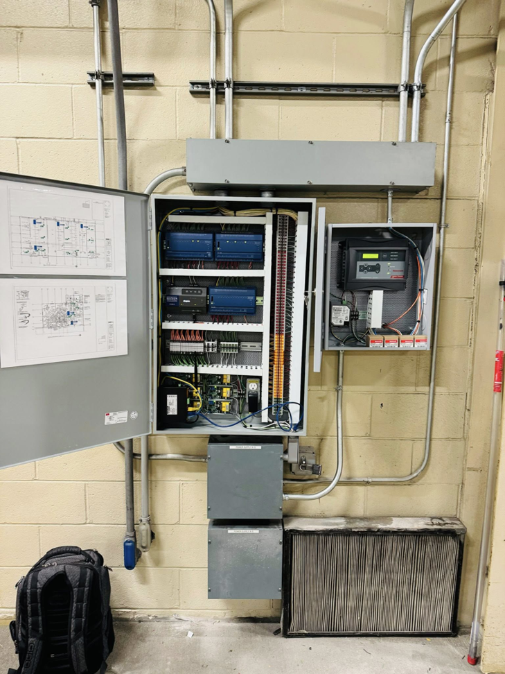 An open HVAC control panel with an air filter on the floor, installed by ICM Mechanical & Controls, LLC in Fall River, MA