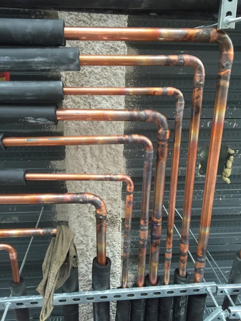 Copper refrigerant lines, some insulated, installed for an HVAC system by ICare Heating & Air in Millcreek, UT.