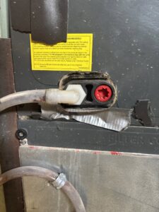 A close-up view of a drain line connection on an indoor HVAC unit, likely during inspection or service by Dad's Heating and Cooling in Blue Springs, MO.