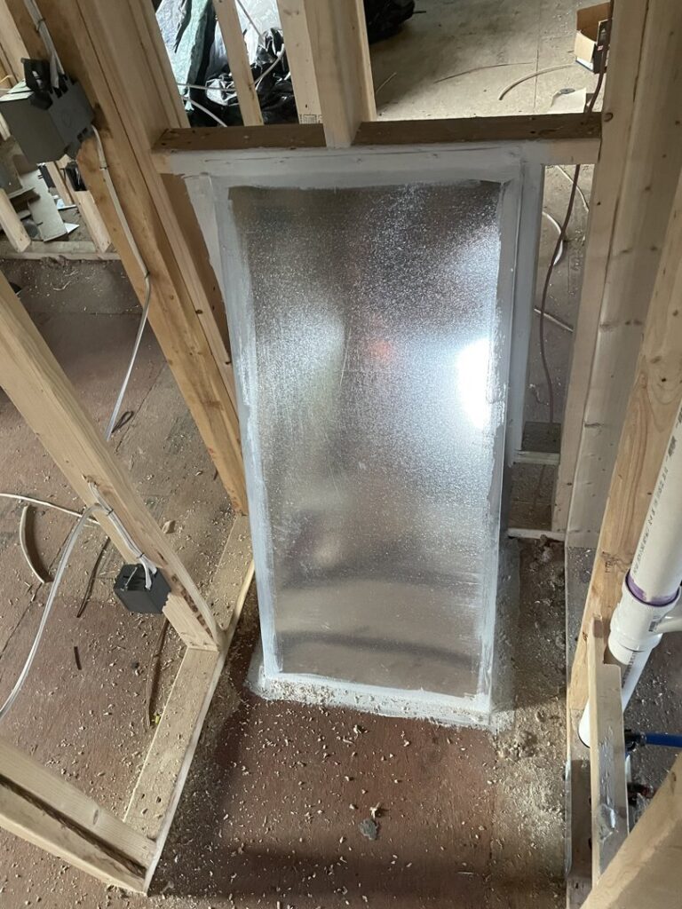 Large rectangular HVAC duct being installed within wall framing during construction by Elite Home Comfort in Clarksville, TN