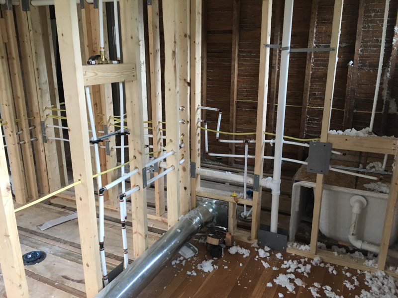 HVAC ductwork and plumbing pipes installed in a framed wall during new construction by Ash Plumbing, Drain & Sewer in Akron, OH.