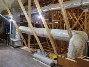 New HVAC ductwork and an air handler unit being installed in an attic by Fusion Heat and Air in Fort Smith, AR.