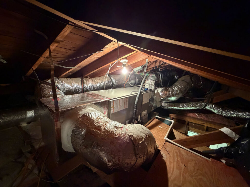 HVAC ductwork and an air handler unit installed in an attic by J&W Heating and Air + Plumbing in Jacksonville, FL.