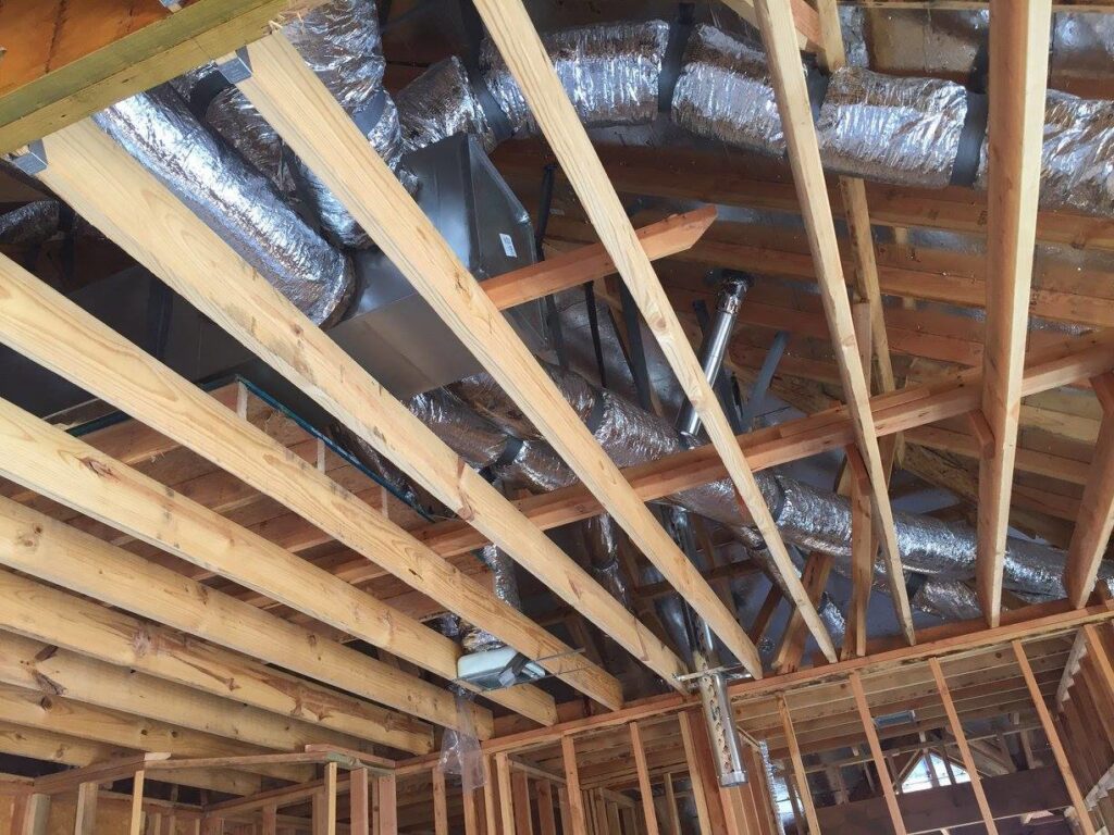 HVAC ductwork and an air handler unit being installed in the attic of a new construction project by Prudhom Mechanical LLC in Edmond, OK