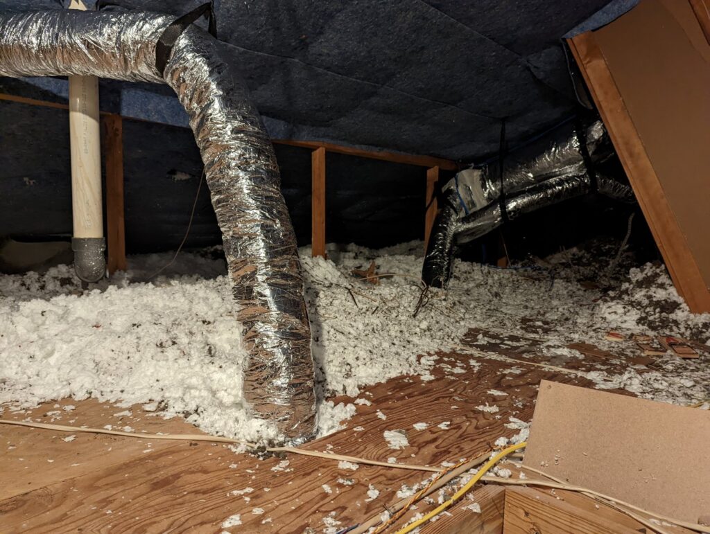 HVAC ductwork and insulation visible in an attic, representing work by Airtegrity Comfort Solutions in San Antonio, TX