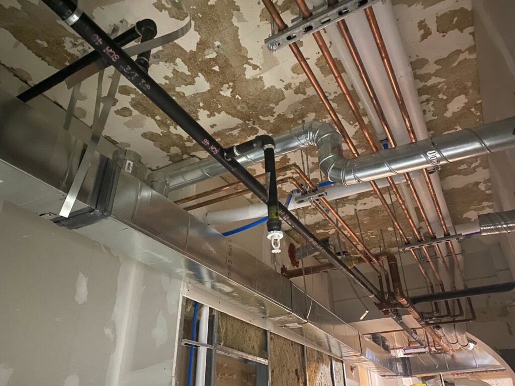 New HVAC ductwork and piping being installed during a construction project by Cafco Services in Cincinnati, OH.
