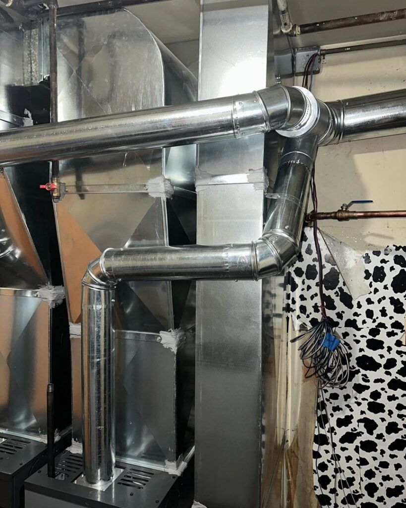 Complex metal HVAC ductwork and piping installed in a utility area by Deboque Duct Design Corp. in Staten Island, NY