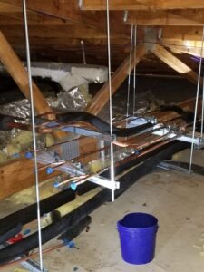HVAC ductwork and copper piping being installed in an attic or crawl space by Comfort Systems of Virginia, Inc. in Chesapeake, VA.