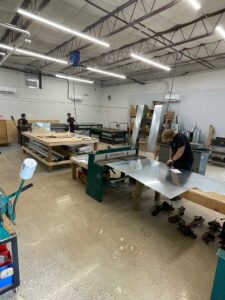 HVAC technicians fabricating sheet metal ductwork in a workshop for Integrity Aire in St. Charles, MO.