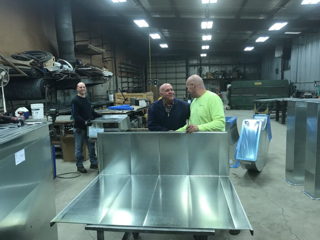 Technicians fabricating sheet metal ductwork in the Montefusco HVAC workshop in Peoria, IL