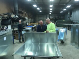 Technicians fabricating sheet metal ductwork in the Montefusco HVAC workshop in Peoria, IL