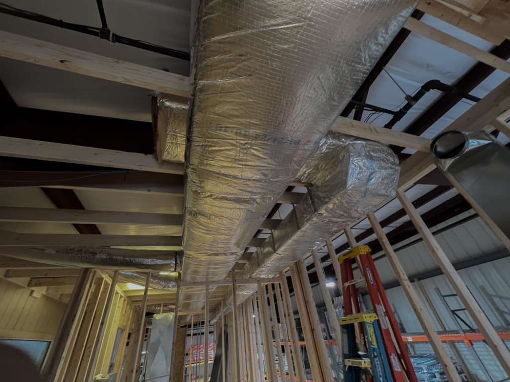 Insulated HVAC ductwork being installed in a new construction building by BRI Mechanical in Charleston, WV