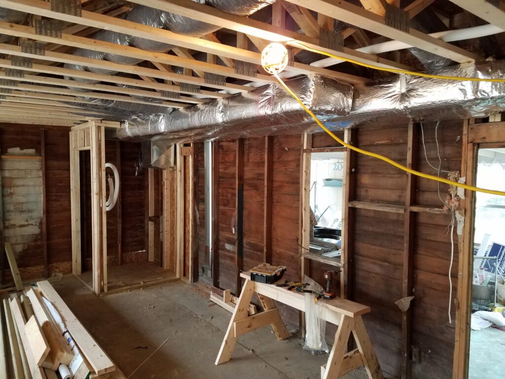 New HVAC ductwork being installed in the ceiling of a residential construction project by Shook Heating And Cooling in Livonia, MI.